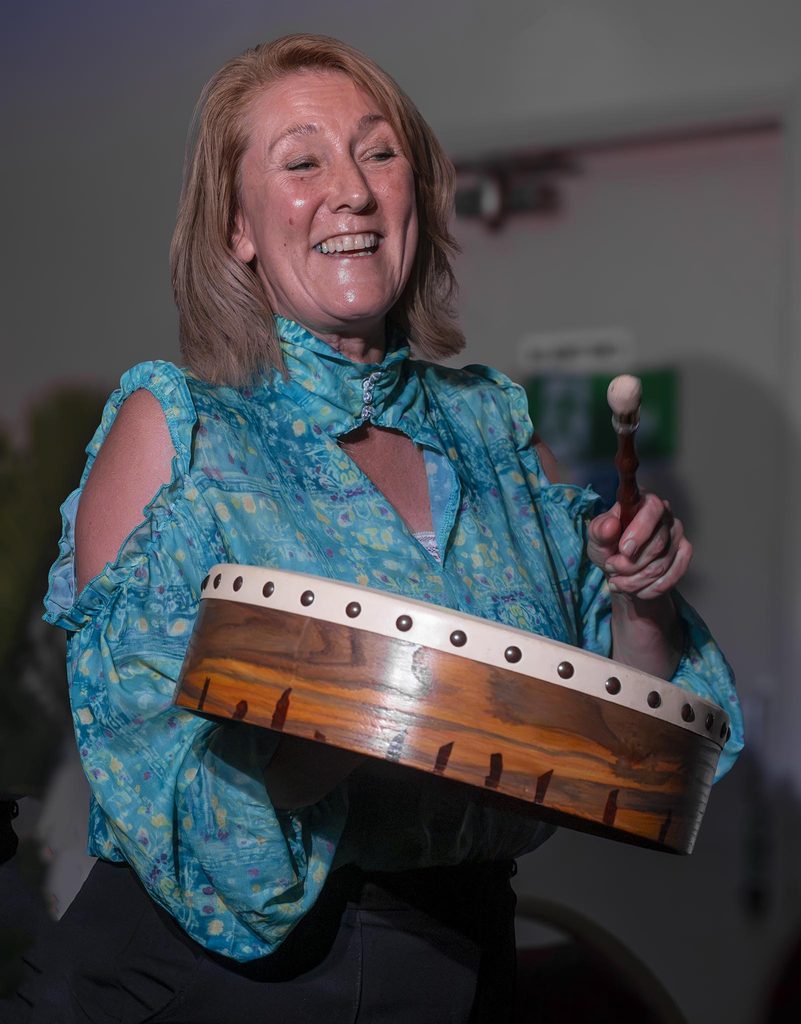 Virginia Kettle playing drum and singing
